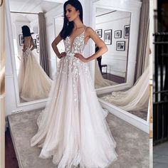 a woman standing in front of a mirror wearing a white dress with flowers on it