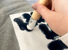 a person is using a pen to draw letters on paper with black ink and white crayons