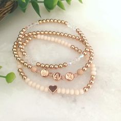 "BLUSH STACK 🌸 3 BRACELETS  * high quality metal spacer beads available in 14k gold fill, or 14k rose gold fill  * rose crystals & stardust accents  * peach faceted oval beads & small heart shape charm  * iridescent crystals 🌷Rose Gold option comes with 14k rose gold filled round beads, rose gold letters, rose gold stardust beads on sides of letter beads & rose gold colored heart 🌻Gold option comes with 14k gold filled round beads, white with gold letters, gold stardust beads on sides of lett Minimalist Rose Gold Bracelet With Custom Name, Dainty Rose Gold Bracelets For Personalized Gift, Dainty Rose Gold Bracelet For Personalized Gift, Custom Name Rose Gold Bracelets For Mother's Day, Custom Rose Gold Dainty Bracelet, Personalized Rose Gold Bracelets For Mother's Day, Delicate Stackable Rose Gold Bracelets, Customizable Rose Gold Bracelets For Everyday Wear, Delicate Rose Gold Stackable Bracelets