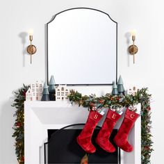 a fireplace with stockings hanging from it's mantle and a mirror on the wall