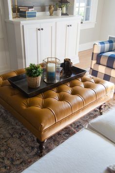 a living room filled with furniture and a tray on top of a coffee table in front of a couch