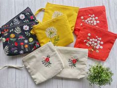 four small pouches with embroidered flowers on them