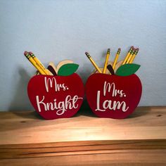 two red apples with pencils in them that say mr and mrs