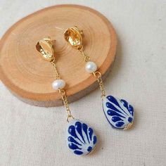 We combine art and elegance to create this beautiful piece. Our handmade earrings will be the perfect element to make your outfit standout. You could have the entire collection or gift them to someone special.  Material: Real Gold plate brass, Talavera, genuine peals.  Dimensions: Drop Length 7cm , width 3cm Features : Lightweight, Unique and Simple design The Talavera of Puebla is part of the intangible heritage of humanity, declared by UNESCO. It is a type of majolica ceramic with a mixture of Chinese, Italian, Spanish, and indigenous techniques, and its colors are obtained from natural pigments. Its main characteristics are its vitreous finish and the use of bulky cobalt blue, this made it even more exclusive and ostentatious than Spanish craftsmanship. Its production requires at least Elegant Handmade Plug Earrings As Gift, Handmade Bohemian Pearl Earrings As Gift, Gold Plated Teardrop Earrings For Gift, Handmade White Gold-plated Earrings, Elegant Handmade Gold Plated Plug Earrings, Gift Pearl Drop Clip-on Earrings, Handmade Gold Plated Flower Earrings For Wedding, Clip-on Dangle Earrings With Pearl Drop For Gift, Unique Gold Teardrop Earrings Gift