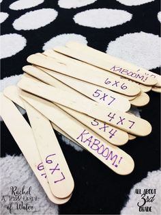 wooden clothes pins with numbers on them sitting on a black and white tablecloth that has polka dots