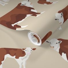 a brown and white cow pattern on a wallpaper with a roll of paper next to it