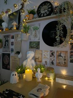 a table with candles, plants and pictures on the wall behind it is a clock