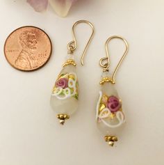 Old World-looking Venetian Wedding Cake beads present beautifully as bridal earrings. Venetian Wedding Cake drop beads measure 20 MM x 10 MM. Opal 4MM Swarovski crystal bicones crystals sit atop 24K vermeil findings, including bead caps.All 24K vermeil findings and 14K GF handcrafted ear wires.The earrings measure 2" from the top of the handcrafted 14K GF ear wire. Wedding Yellow Gold Jewelry With Dangling Beads, Elegant Czech Glass Jewelry With Gold Beads, Elegant Jewelry With Gold Beads And Czech Glass, Gold Earrings With Round Beads For Wedding, Czech Glass Dangle Earrings For Wedding, Gold Beaded Earrings With Round Beads For Wedding, Gold Round Beads Earrings For Wedding, Czech Glass Round Jewelry For Wedding, Beaded Drop Jewelry For Wedding