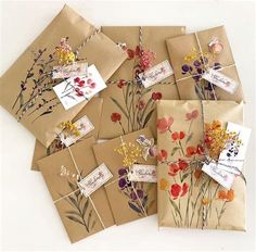 six brown envelopes with flowers on them are tied together and have tags attached to them