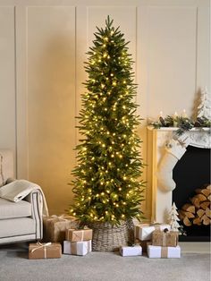 a christmas tree with presents under it in front of a fireplace