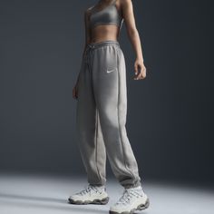 Find NIKE Sportswear Phoenix Fleece High-waisted Oversized Sweatpants on Editorialist. Grounded in style, comfort and versatility, meet our take on luxury loungewear. Whether you're running errands or rewatching your favorite show, these midweight fleece sweats feel extra soft on the inside to help keep you cozy. The oversized fit is intended to sit high on your hips for comfort and a stay-put feel. Benefits:Encased elastic waistband and drawstrings ensure a fit that feels just right. Pockets pr Athleisure Streetwear Joggers With Elastic Waistband, Athleisure Joggers With Elastic Waistband For Streetwear, Athleisure Sweatpants With Elastic Waistband For Streetwear, Sporty Activewear For Fall Streetwear, Athleisure Sweats With Elastic Waistband For Streetwear, Urban Style Sports Activewear With Elastic Waistband, Urban Activewear With Elastic Waistband For Sports, Gray Sports Sweats, Nike Joggers With Ribbed Waistband For Jogging