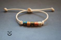 "This is a listing for 1 name cord bracelet with multicolour resin beads, made out of waxed cotton (2mm), in the colour of your choice. - 100% handmade in France - the bracelet will wrap once around your wrist and makes for a nice subtle accessory bringing out the outdoor and adventurous person in you. - the bracelet makes a great gift, the bracelet comes in a fabric gift bag ready to be offered as a present.  SIZE There are 2 sizes available specially because the bracelet is adjustable due to s Adjustable Beaded Bracelets With Waxed Cord As Gift, Everyday Multicolor Waxed Cord Jewelry, Everyday White Waxed Cord Bracelets, Adjustable Multicolor Name Bracelet, Adjustable Custom Name Friendship Bracelets For Everyday, Custom Name Adjustable Friendship Bracelet For Everyday, White Waxed Cord Friendship Jewelry, Multicolor Beaded Bracelets On Waxed Cord As Gift, White Resizable Waxed Cord Friendship Bracelets