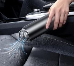 a person is cleaning the inside of a car with a hand held dryer on it