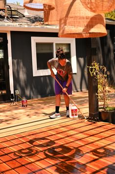 a woman is cleaning the deck with a mop