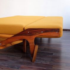 a wooden bench sitting on top of a hard wood floor