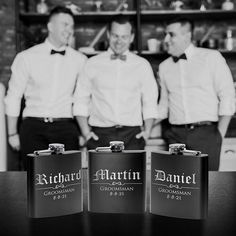 three men standing next to each other in front of a shelf with liquor cans on it