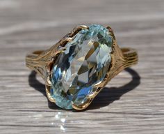 The Inagua Ladies Vintage Signed 14K Ring set with 5.54 CT Aquamarine. Crafted in 14 karat yellow gold, this ring features a 5.54 carat aquamarine center stone. Exquisite hand engraved leaves hold the center stone in place, while adding an artistic vibe to the piece. The ring is signed GUMPS on the inner shank and is currently a finger size 7.5. This ring is able to be resized for an additional charge upon request. Each piece has been hand selected and meticulously identified and graded by a Gra Yellow Gold Aquamarine Jewelry With Center Stone, Formal Aquamarine Solitaire Jewelry, Light Blue 14k Gold Formal Jewelry, Light Blue 14k Gold Jewelry For Formal Occasions, Formal Light Blue 14k Gold Jewelry, Artistic Vibe, Filigree Engagement Ring, Antique Diamond Rings, Yellow Gold Engagement