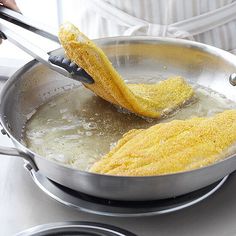 someone is frying corn on the cob in a skillet