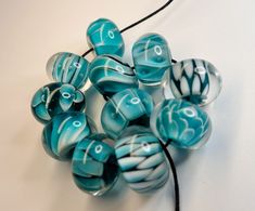 several blue and white glass beads on a black cord