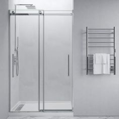 a bathroom with a glass shower door and towel rack