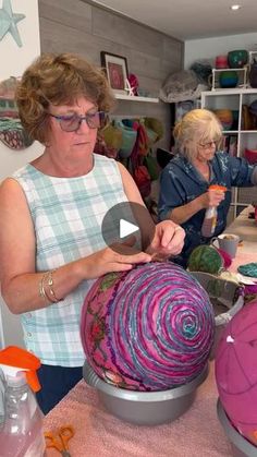 two women are working on an art project in a room full of craft supplies and crafts