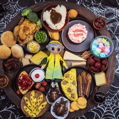 an assortment of food is arranged on a wooden plate with black and white pattern cloth