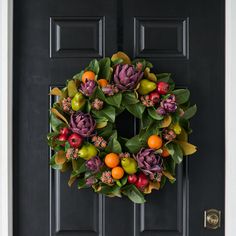 a wreath on the front door with fruit and flowers