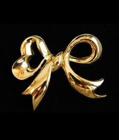 "Fun and Chic and Gorgeous jewelry piece from Nina Ricci back in the 90''s. Great gift idea. Free gift wrapping. Introducing a vintage Nina Ricci golden bow brooch pin. It features a heart shape bow on the left side. In the back has its signature stamped plate. Gently used. Slight darkening in the back. Overall, it is still in a great vintage condition with little damages of use and ages. Material: GP Measurement: W2.2\"(5.7cm) x H1.77\"(4.5cm) *Free gift wrapping upon request Please feel free t Vintage Gold Brooches For Formal Occasions, Vintage Yellow Gold Brooches For Party, Classic Gold Brooches For Anniversary, Gold Brooches With Ribbon Ideal For Gifts, Classic Gold Party Brooch, Vintage Jewelry With Decorative Bow For Formal Occasions, Vintage Ribbon Brooches, Retro Gold Brooches For Evening, Gold Retro Brooches For Evening