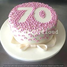 a birthday cake decorated with pink sprinkles and the number 70 on top