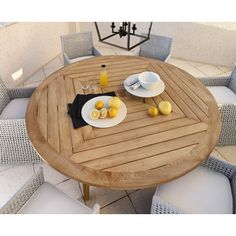 an outdoor table with plates and cups on it, next to some lemons and orange juice