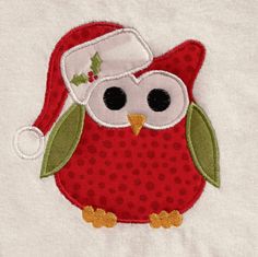 an appliqued red owl with a santa hat on it's head