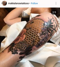 a woman laying on top of a bed with a tattoo on her arm and leg