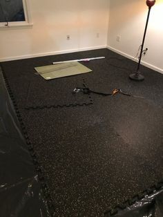 an empty room with a black floor and some tools on the ground next to it