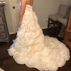 a woman in a white wedding dress looking at herself