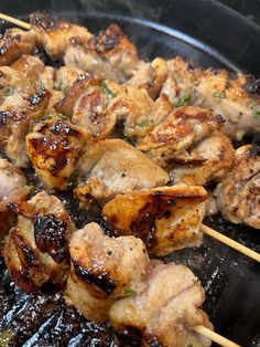 chicken and meat skewers being cooked on a grill