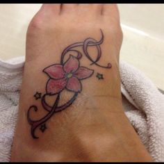 a woman's foot with a flower tattoo on her left ankle and stars around it