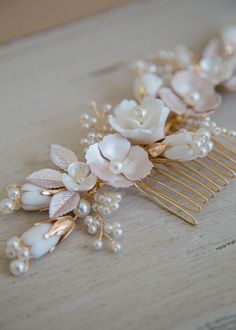 a hair comb with flowers and pearls on it