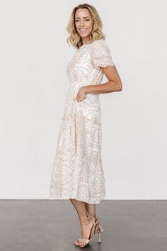 Go-to midi dress featuring gorgeous details White with natural beige embroidered eyelet pattern throughout Cotton material has no stretch High neckline with ruffle detail Keyhole and button closure at back Short, layered scallop sleeves Elastic waistband Functional side pockets Tiered midi skirt with ruffle details Fully lined excluding sleeves Self and Lining: 100% Cotton Due to the extensive embroidery, please note that this dress may arrive with loose threads that need to be trimmed. Trina is 5'6, cup size 32D, size 2 and is wearing size S White A-line Midi Dress With Smocked Bodice, White A-line Midi Dress With Gathered Sleeves, Fitted V-neck Midi Dress With Broderie Anglaise, Feminine Midi-length Eyelet Dress, White V-neck Broderie Anglaise Midi Dress, Scalloped Shorts, Tiered Midi Skirt, White Midi Dress, High Neckline