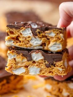 someone holding up some kind of dessert bar with marshmallows and chocolate on top