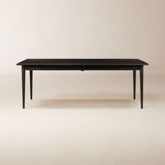 a black table sitting on top of a white floor next to a brown wall in the background