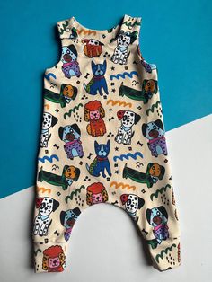 Baby/toddler romper in unisex multicoloured puppy dog print. Comfortable clothing for babies and toddlers made from soft jersey fabric. Harem pant leg style means they are roomy enough for both cloth and regular nappy wearing babies. Sizes available from 0-2 years. Check sizing (below) before ordering. Sewn using a Brindille & Twig sewing pattern. FABRIC All fabrics are OKEO-TEX certified or Organic and printed in Europe. Wash warm or cool on a delicate setting. A small amount of shrinkage may occur on first wash. Also available in this print...harem pants GIFTS If your order is a gift items can be sent direct to recipient. Make it special by selecting the gift wrap option and let me know if you'd like to include a handwritten card. SIZING Romper length in inches and (cm) 0-3m 20.3 (51.6) Cotton Cartoon Print Jumpsuits And Rompers For Playwear, Cotton Jumpsuits And Rompers With Cartoon Print For Playwear, Cotton Playwear Jumpsuits And Rompers With Cartoon Print, Playful Unisex Onesie With Cartoon Print, Playful Printed Onesie For Playtime, Playful Cotton Jumpsuits And Rompers For Playtime, Multicolor Cartoon Print Onesie For Playwear, Playful Multicolor Character Print Onesie, Cotton Bubble Romper With Cartoon Print For Playwear