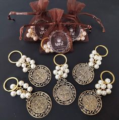 five pieces of jewelry sitting on top of a table next to a bag and ribbon