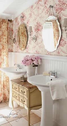 a bathroom with floral wallpaper and two sinks