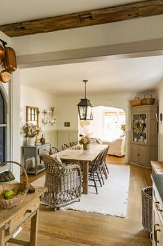 the dining room table is surrounded by wicker chairs and an old - fashioned light fixture