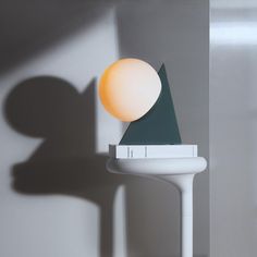 a lamp that is sitting on top of a white table next to a book shelf