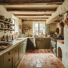 This charming English countryside kitchen showcases the beauty of earthy tones, with exposed wooden beams, terracotta floor tiles, and olive green cabinets working together to create a cozy, welcoming space French Countryside Aesthetic Interior, Countryside House Kitchen, Home Feeling, Italian Country Kitchen Farmhouse Style, English Country Style Kitchen, Villa Kitchen, English Cottage Style Kitchen, Italian Country Kitchen, European Farmhouse Kitchen