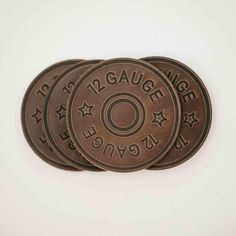 three bronze coins with the words, 12 gauge and stars on them are sitting in front of a white background