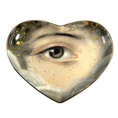 a heart shaped bowl with an eye in the center and gold flecks on it