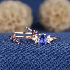 an image of a ring with a tan diamond and blue sapphire stone in it on a blue cloth