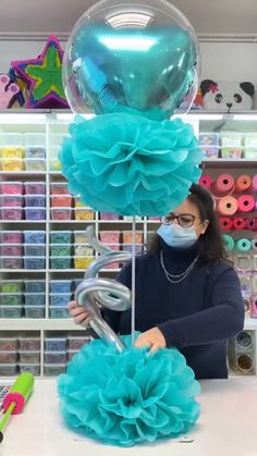 a woman wearing a face mask is making balloons